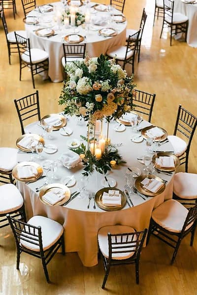 Close up of gold charger plate with flowers for wedding table rental